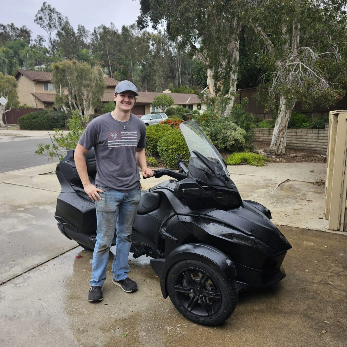 Zach Lahlum standing with a customer's Can-Am Spyder RT in a San Diego driveway
